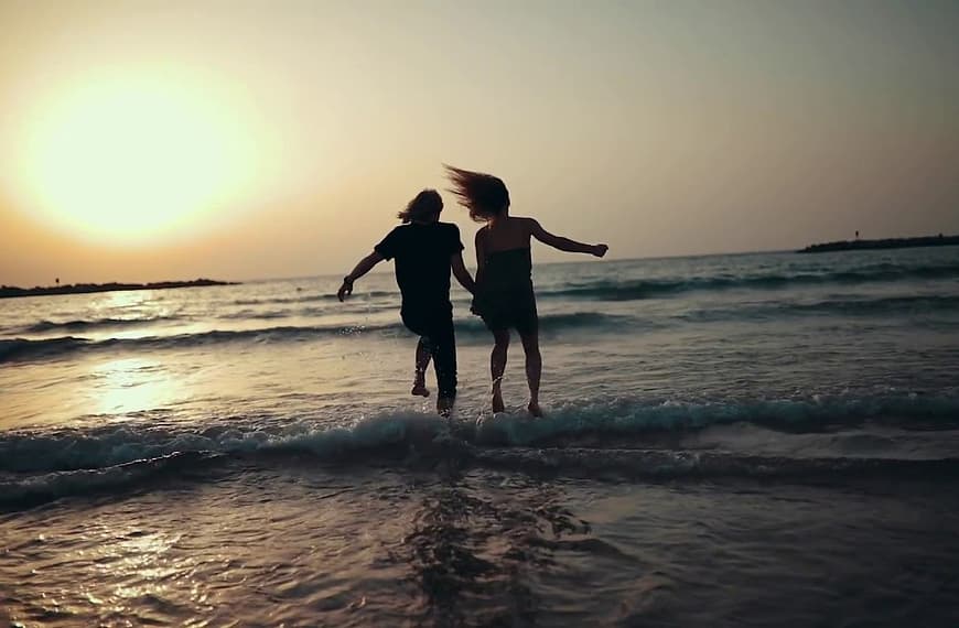 Couple on beach in sunrise video